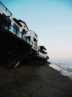 黃昏時分高蹺上的現代海濱房屋與海浪