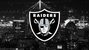 Raiders 標誌在夜晚城市上空，有橋樑和起重機