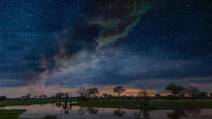 星空、北極光與銀河在黃昏的濕地中倒映。 — 星星 壁紙