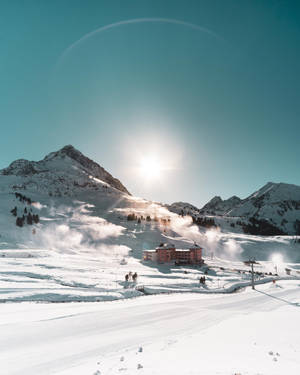 積雪的山區度假村，滑雪者和滑雪纜車在明亮的陽光下。