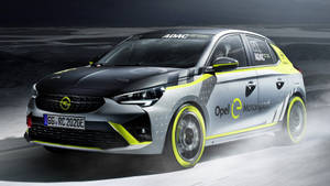 Opel e-Motorsport賽車在夜間濕滑賽道上疾馳，帶有黃色點綴。