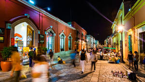 夜晚街道場景，色彩繽紛的建築和模糊的行人。