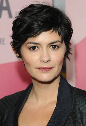 短黑髮女性在活動中穿著黑色外套。