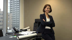 自信女商人穿西裝在現代辦公室微笑，城市景觀背景。 — 辦公室 壁紙