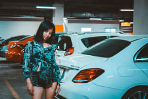 身穿圖案青綠色套裝的女性站在白色Mercedes-Benz AMG旁的地下停車場。 — 汽車 壁紙