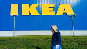 戴口罩的人走過IKEA商店標誌