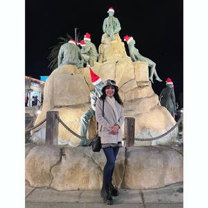 女士在夜晚於節日主題雕像前擺姿勢。 — 雕塑 壁紙