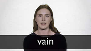 女性穿著黑色襯衫，胸前有 vain 字樣，背景為白色牆壁。