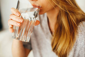 室內用透明玻璃杯飲水嘅人