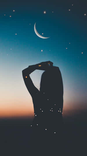 剪影中嘅人喺暮色中睇新月同星星。