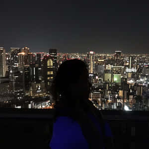 剪影中的人俯瞰夜晚充滿活力的城市。