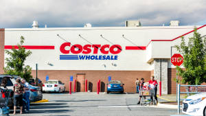購物者推著購物車在多雲的日子裡在 Costco Wholesale 商店外。