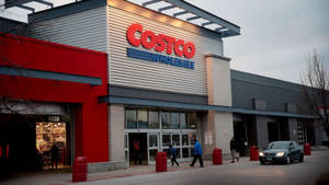 Costco商店入口，購物者和一輛車，黃昏時分。