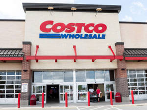 Costco Wholesale 商店入口，有購物者進入和紅色護柱。