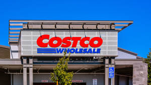 晴朗藍天下 Costco Wholesale 商店入口，標誌和門清晰可見。