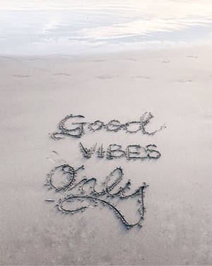 喺海岸線嘅沙上寫住Good Vibes Only，伴隨住海浪。