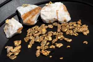 深色岩石表面上的金塊和金片 — 玫瑰金風格 壁紙