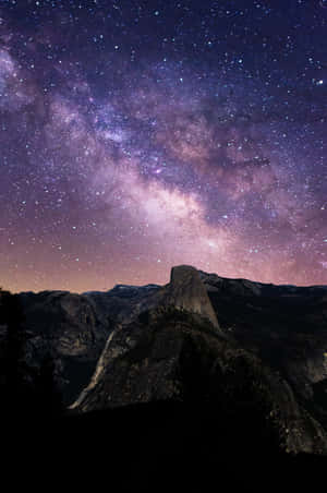 Half Dome 山在充滿活力的星空下，銀河系閃耀。