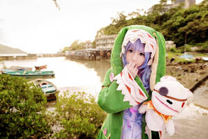 穿著綠色恐龍服裝的Cosplayer在河邊拿著毛絨玩具。