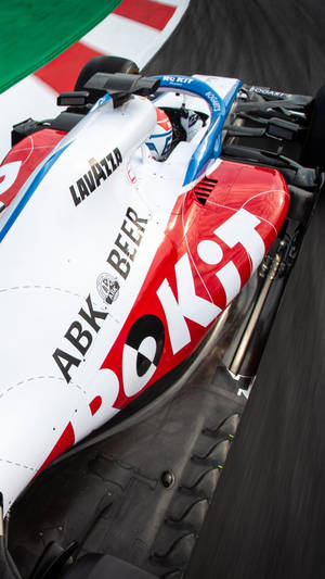 帶有贊助商標誌的 Formula 1 賽車在賽道上飛馳 — 汽車 壁紙