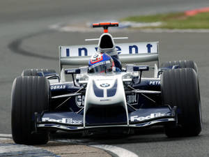 藍銀色威廉姆斯F1賽車在潮濕賽道上疾馳。