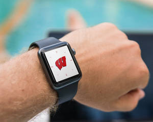 手腕上的智能手錶顯示紅色W標誌。