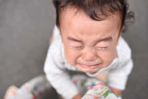 一個閉著眼睛、嘴角下垂哭泣的嬰兒。