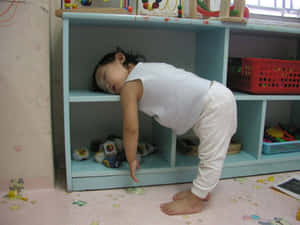 一個眼瞓嘅幼兒喺兒童房嘅藍色架上休息頭部。