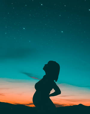 孕婦剪影在黃昏時仰望星空。