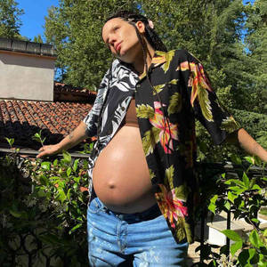 孕婦穿花卉襯衫在晴天戶外站立