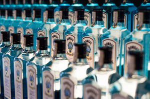 架上一排排藍色 Bombay Sapphire 氈酒瓶，景深較淺。