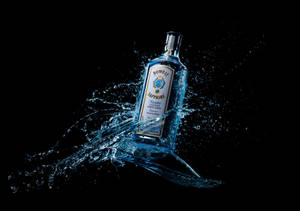 Bombay Sapphire 氈酒瓶被藍色水花圍繞，黑色背景。