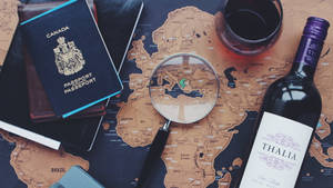 旅行裝備包括護照、放大鏡和葡萄酒在世界地圖上。