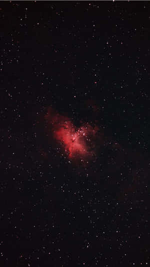 夜空中被無數星星包圍的發光紅色星雲。