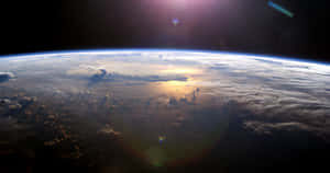 從軌道觀看行星地球，帶有太陽耀斑和雲層圖案。 — 太空 壁紙