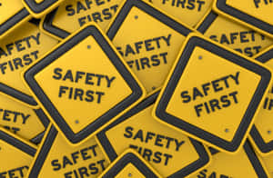 一堆黃色 safety first 警告標誌，帶黑色邊框。 — 黃色 壁紙
