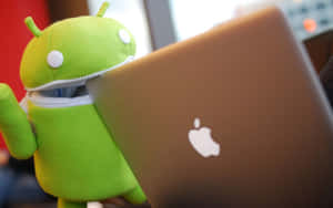 綠色Android毛公仔在Apple手提電腦後面探頭