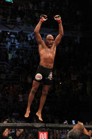 MMA拳手在籠內跳起慶祝勝利。