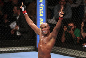 MMA 選手在八角籠中高舉雙臂慶祝勝利。