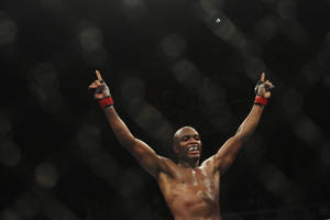 一位勝利的MMA拳手在黑暗的八角籠內舉臂歡呼。