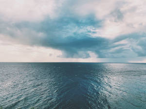 暴風雲籠罩在波濤洶湧的海洋上空，天空陰沉。 — 4:3 壁紙