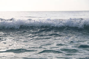海浪撞擊，白色泡沫在平靜地平線前翻騰。 — 3:2 壁紙