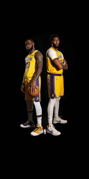 兩名身穿湖人隊球衣的NBA籃球運動員在黑色背景前擺姿勢。