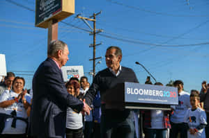 Mike Bloomberg 在競選活動中與支持者握手。