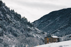 雪山谷中的石屋與常綠樹 — 冬天 壁紙