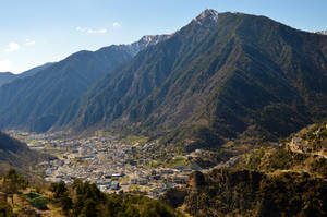 山谷中的山城，在清澈藍天下有白雪覆蓋的山峰。