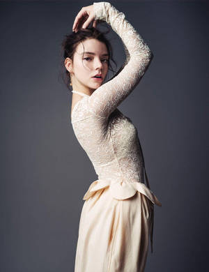 身穿奶油色蕾絲裙的女士，一隻手臂舉起，在灰色背景前擺姿勢。