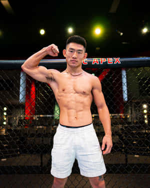 運動員戰士在明亮燈光下的MMA籠內展示肌肉。