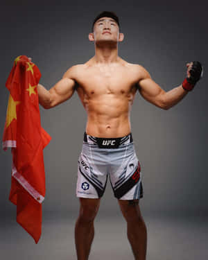 一位赤裸上身的男性拳手在工作室中手持中國國旗慶祝勝利。