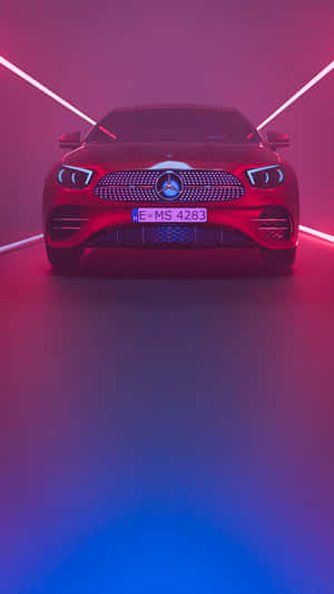 紅色 Mercedes-Benz 汽車在工作室中被粉紅色和藍色霓虹燈照亮。